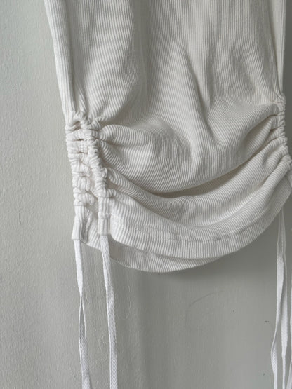 White ribbed knit top with a gathered neckline on a light gray background