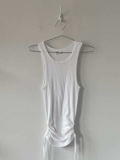 White tank top on a hanger against a plain background
