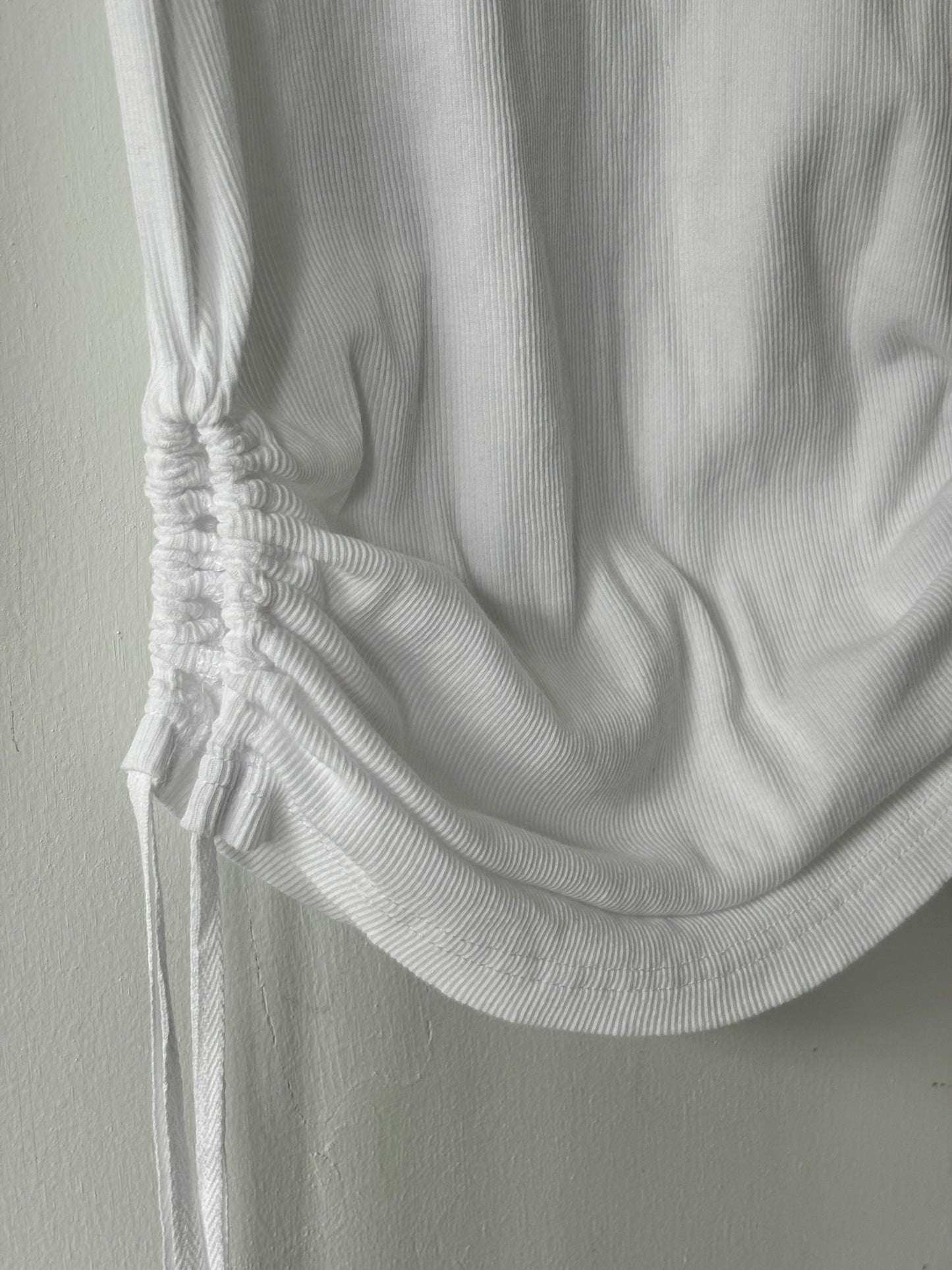 Close-up of a white textured garment on a plain background
