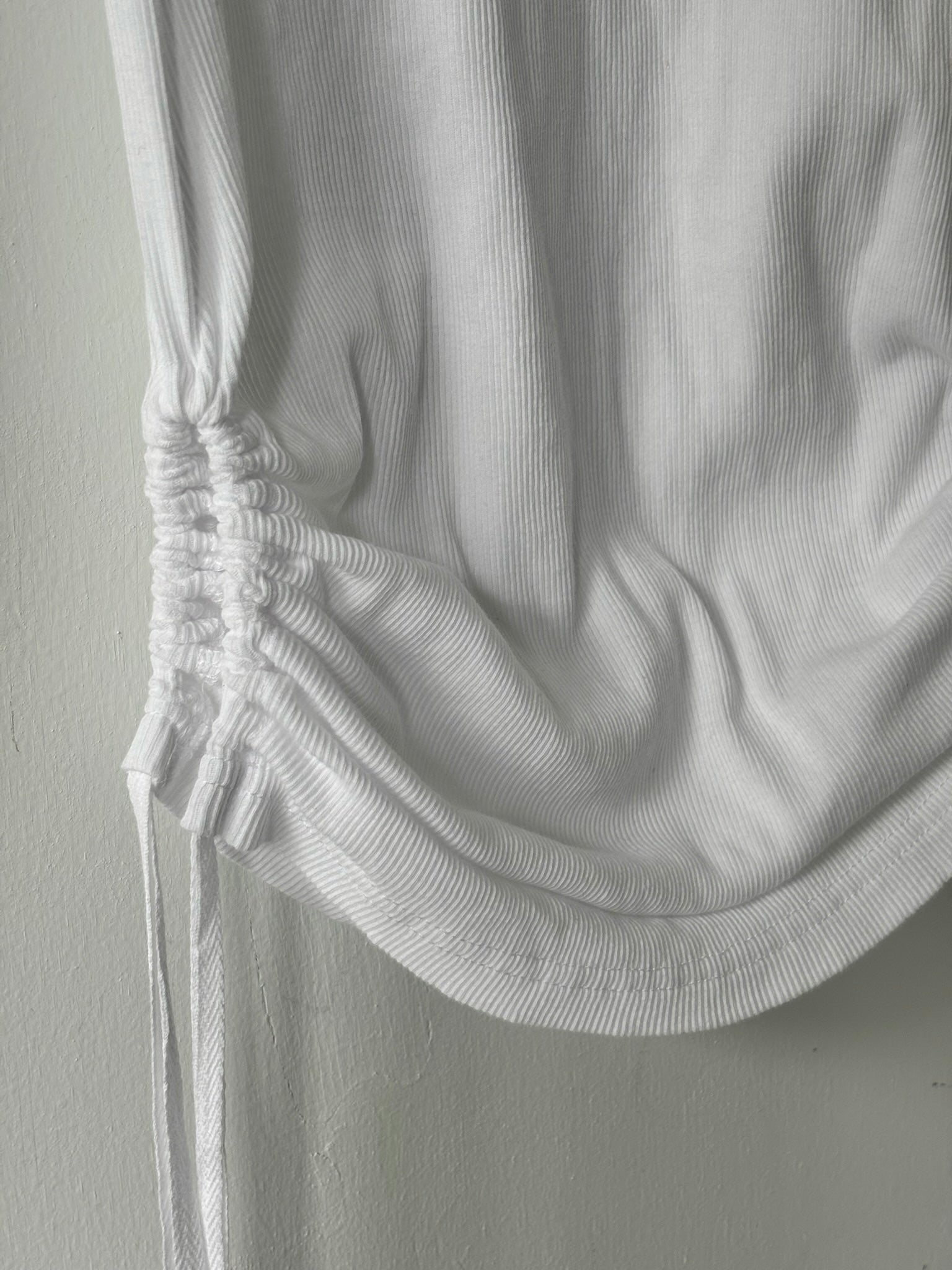 Close-up of a white textured garment on a plain background