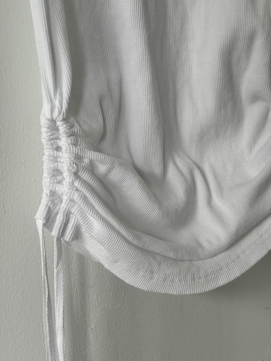 Close-up of a white textured garment on a plain background